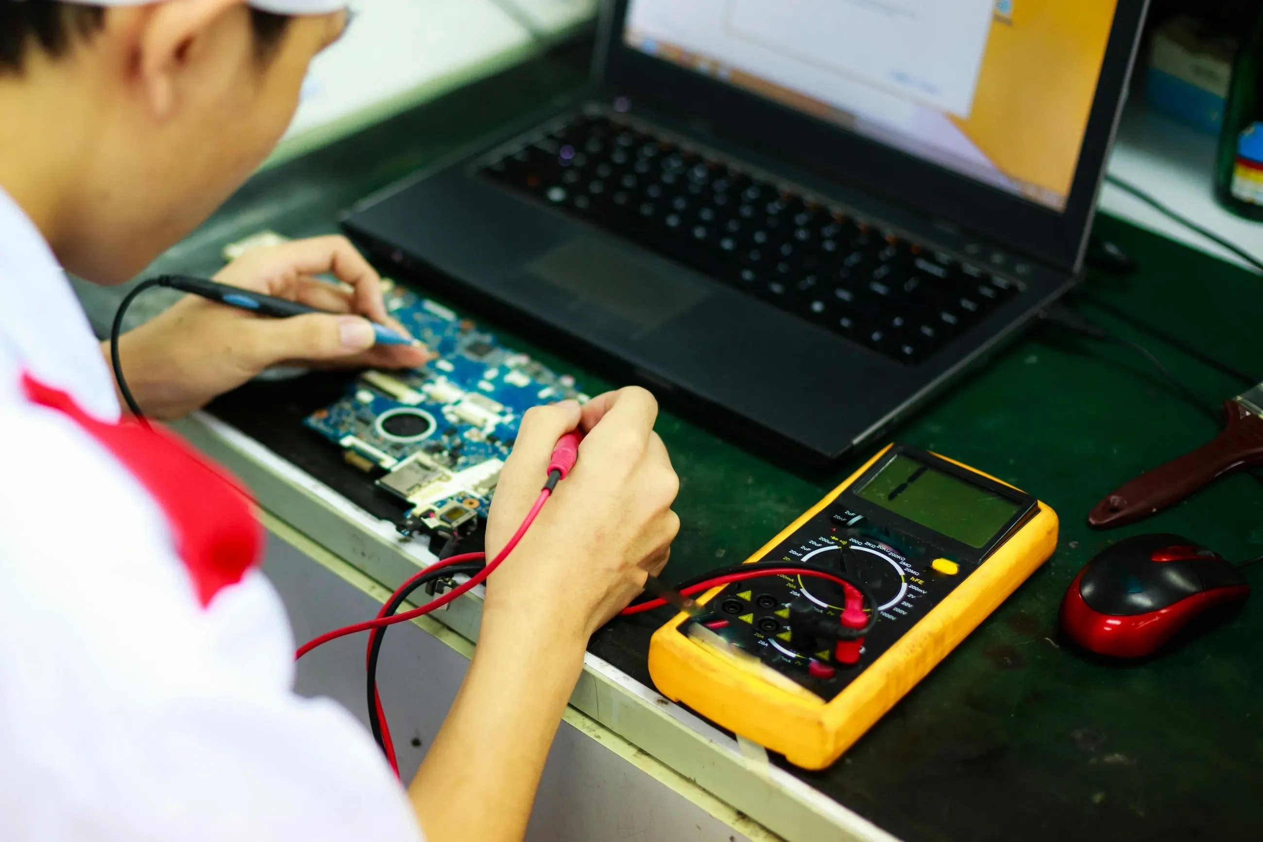engineer testing a pcb with digital multimeter