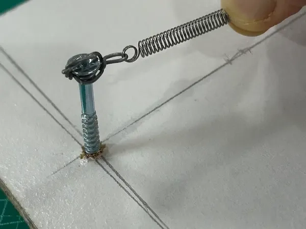 The spring connected to the screw ready to be stretched