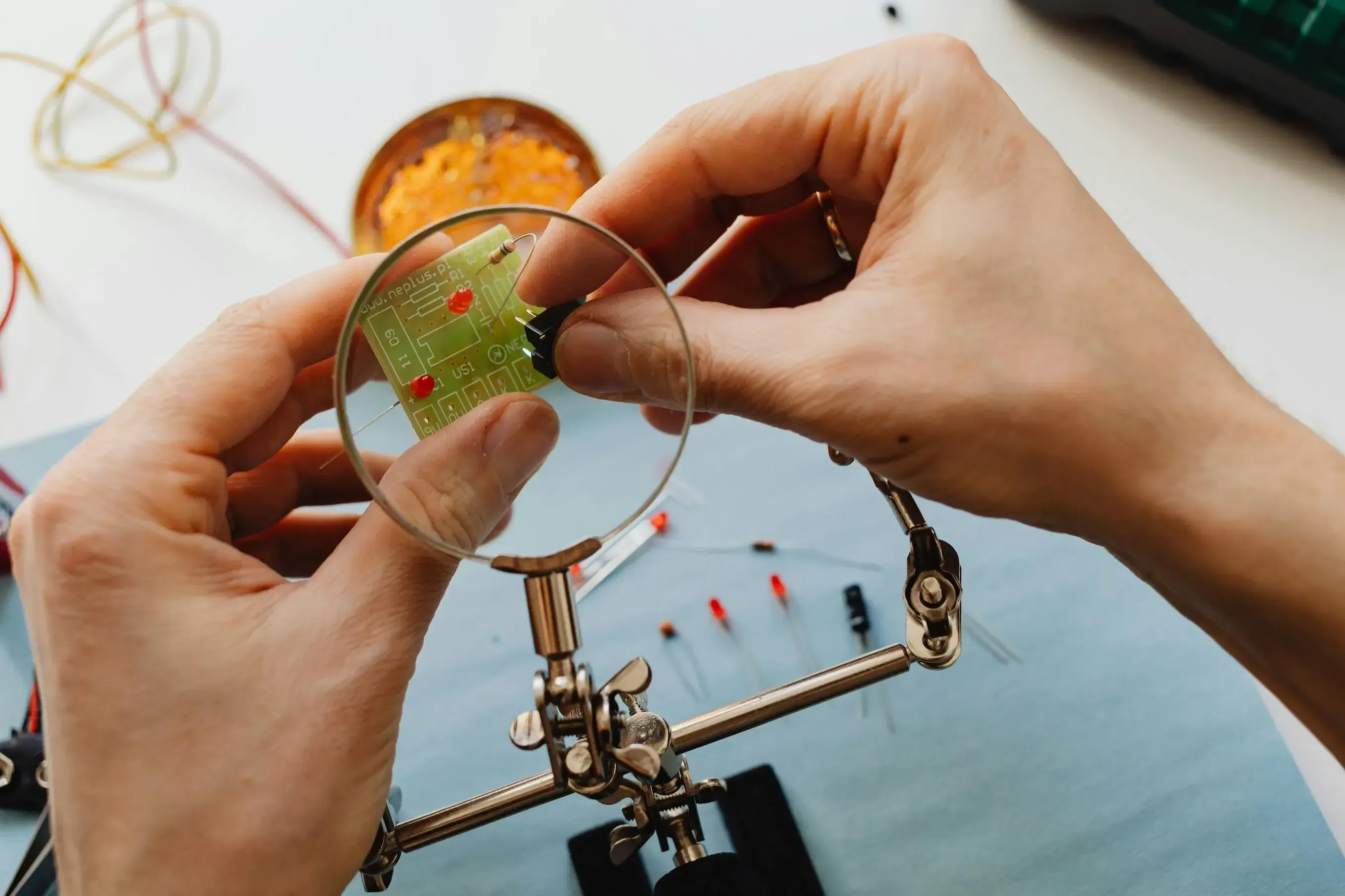 a person soldering an LED in a PCB